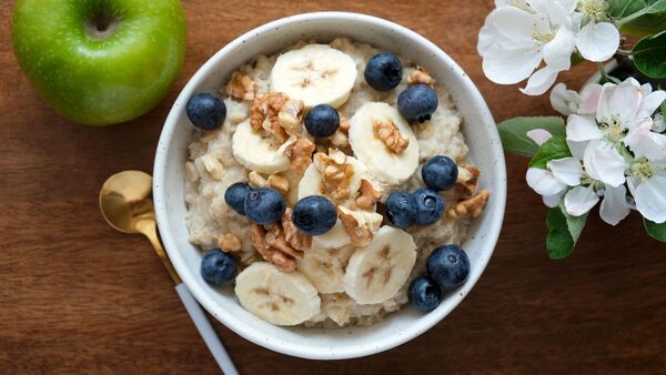 Desayuno simple con frutas y avena sobre una mesa clara